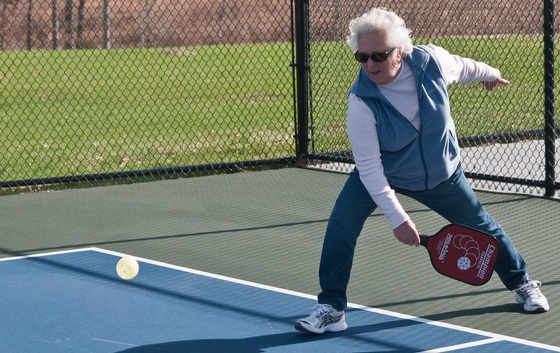 older woman playing pickleball