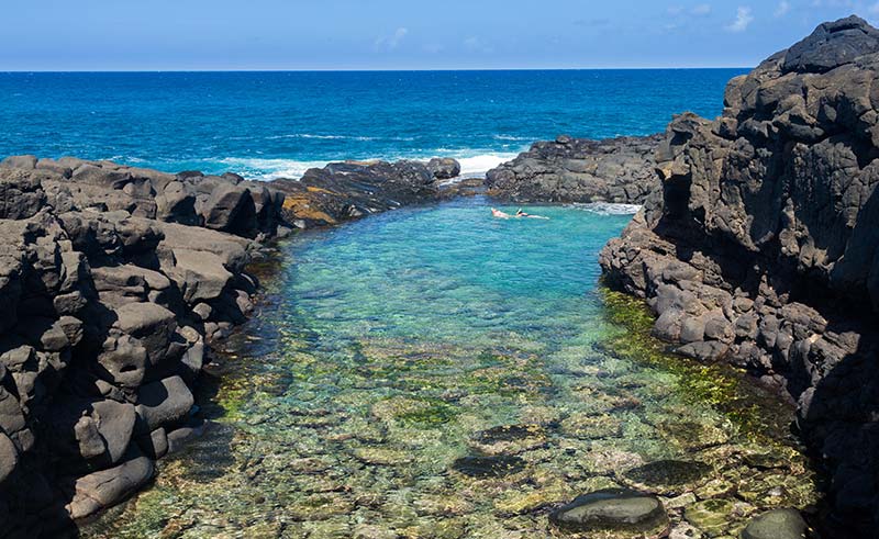 Snorkeling swimmers in Queens Bath near Princeville, Kauai