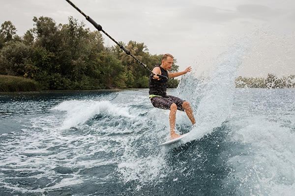 man wakeboarding behind boat