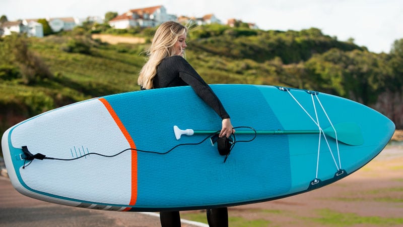 woman holding paddle board