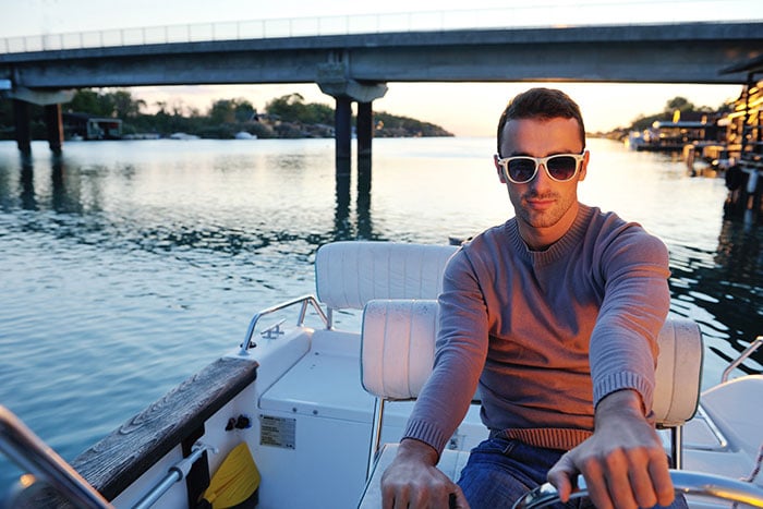 guy in sunglasses driving boat