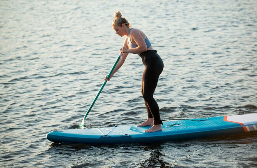 woman paddle boarding in wetsuit