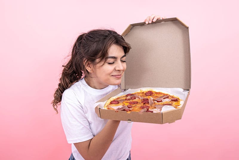 woman sniffing pizza delivery