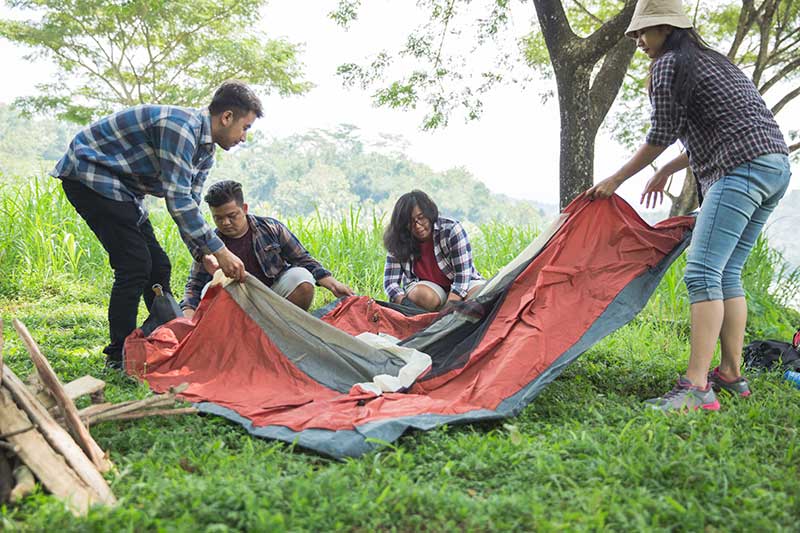 friends breaking down a tent